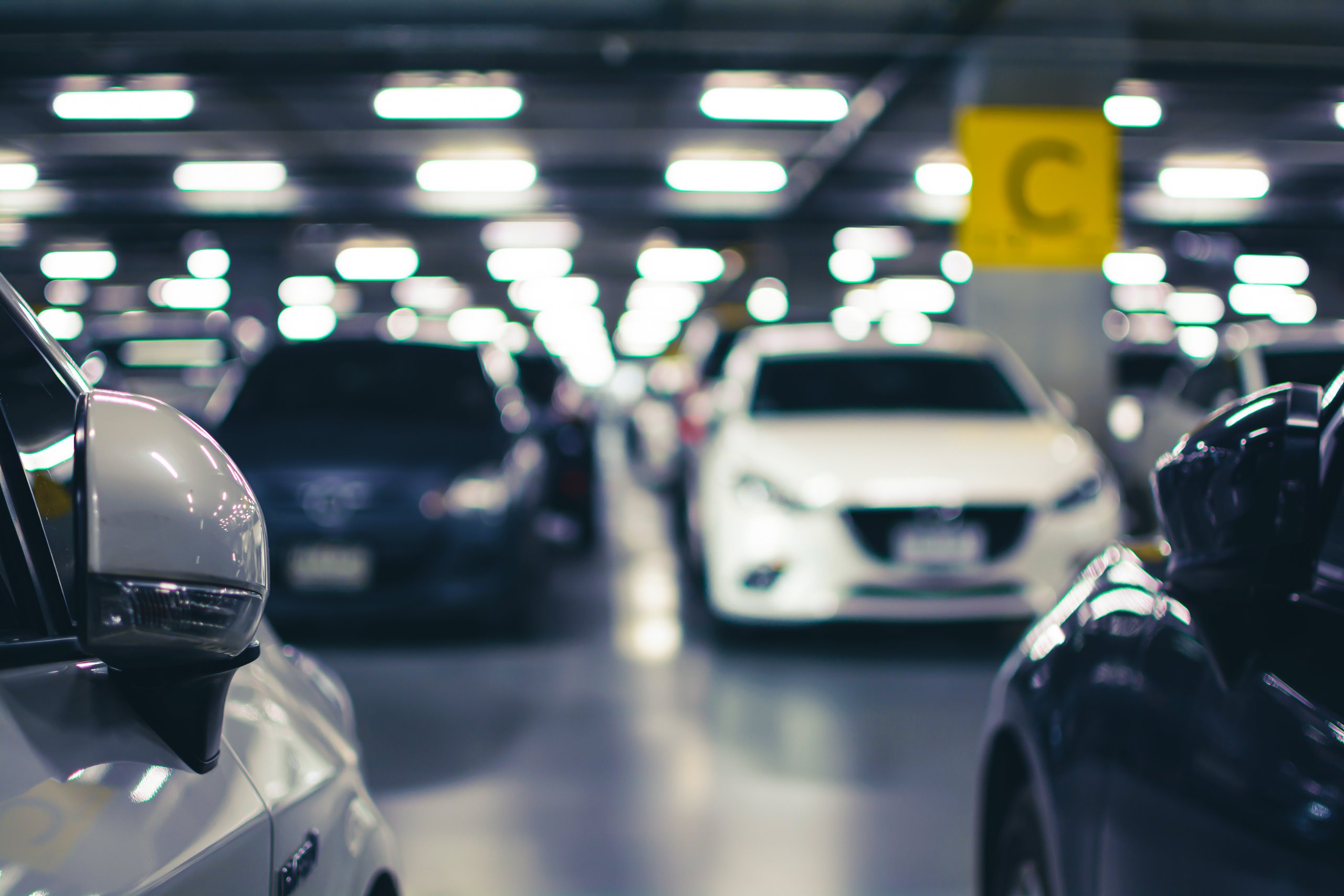 Moderne og godt opplyst parkeringshus med parkerte biler.