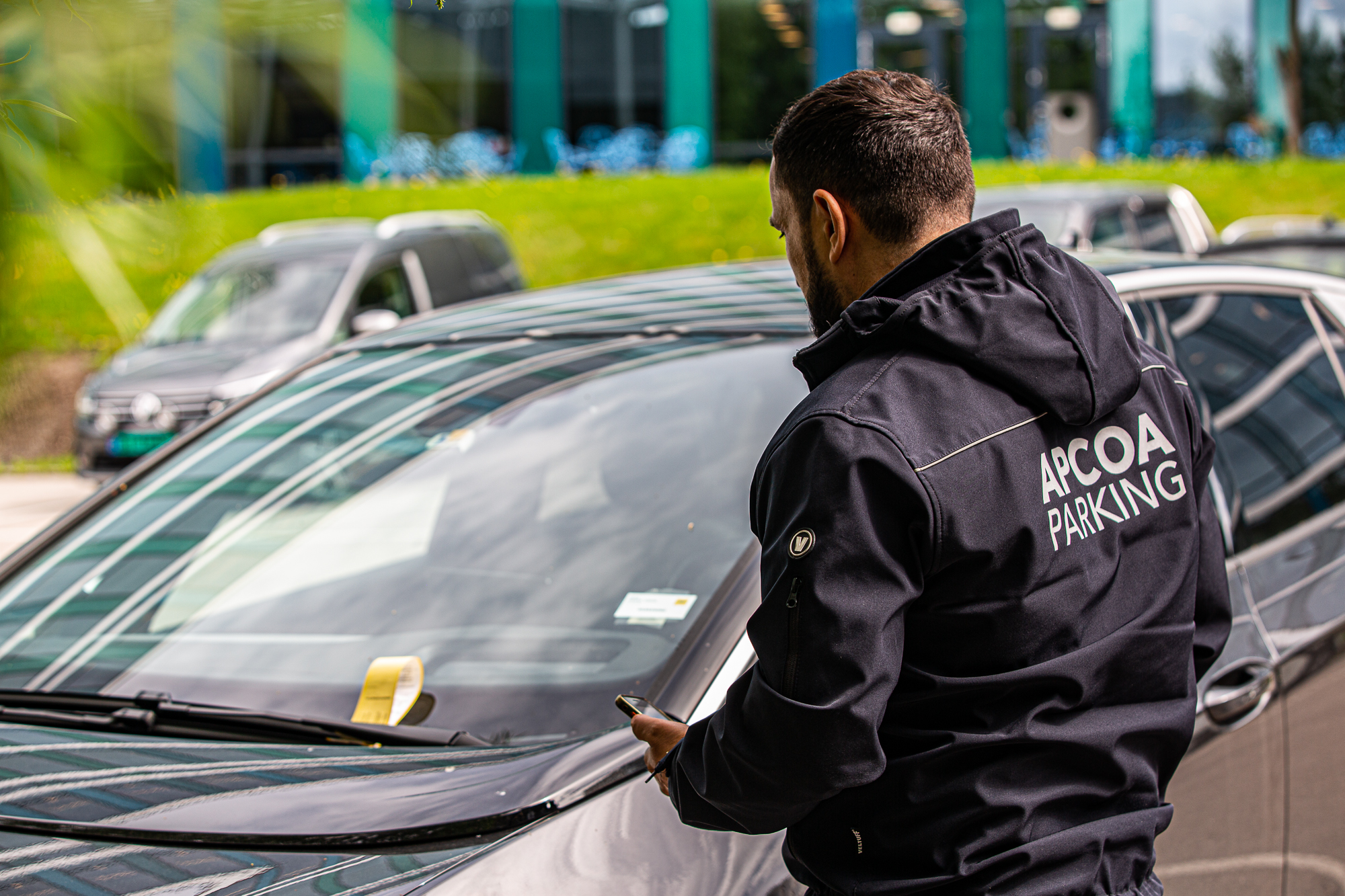 Kontrollbetjent utsteder en kontrollsanksjon på en bil på et parkeringsområde